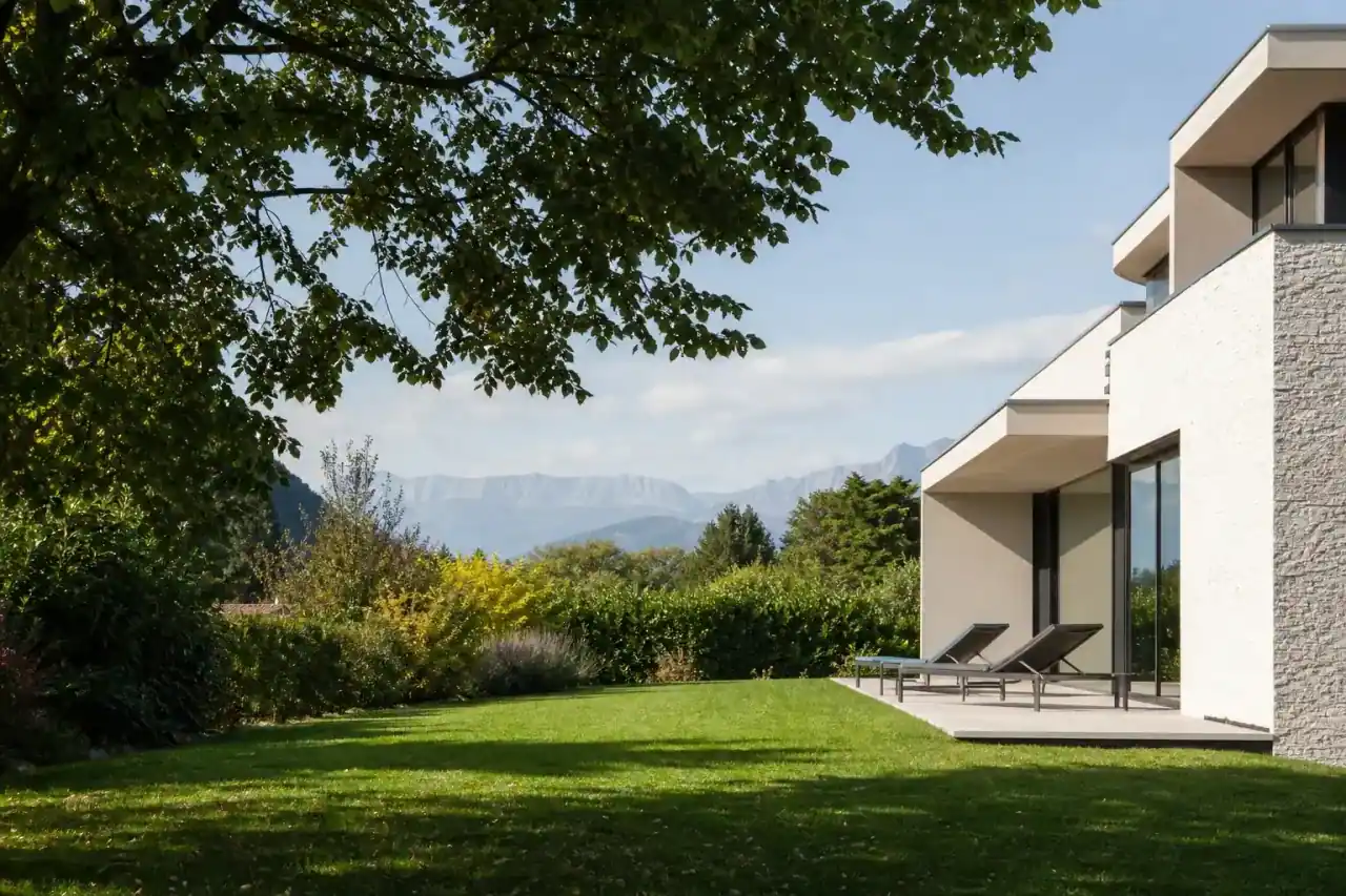 maison contemporaine cossue avec grand jardin arboré, vue dégagée sur relief montagneux, lumière douce de fin de matinée, aucune personne visible
