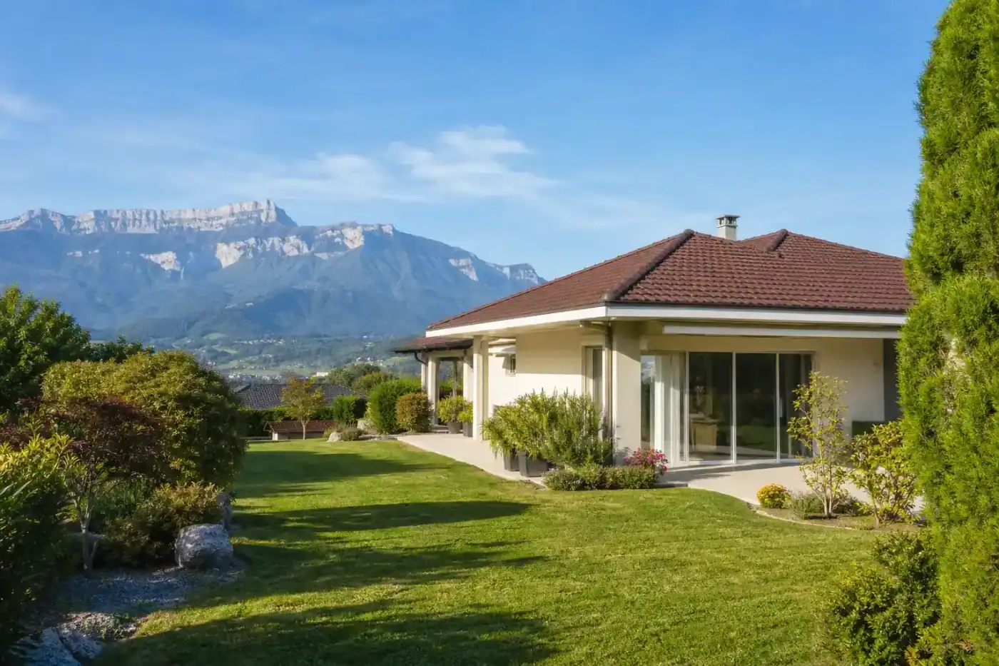 maison traditionnelle plain-pied avec jardin engazonné, vue dégagée sur le Vercors en arrière-plan, matin ensoleillé, aucune personne visible
