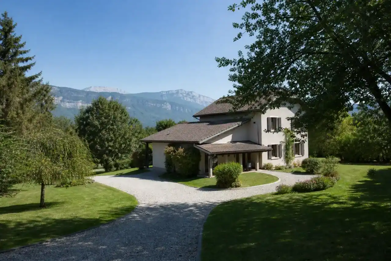 maison familiale sur grand terrain arboré, style régional Voironnais, allée en gravier, journée dégagée, aucune personne visible