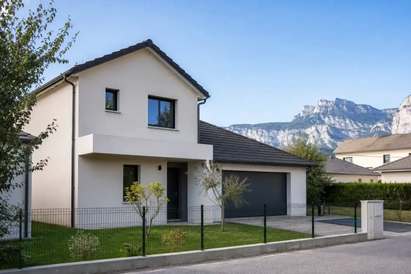 maison individuelle récente en lotissement, façade claire, garage attenant, ciel dégagé, journée neutre, aucune personne visible